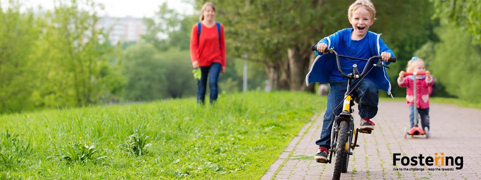 Fostering banner, child on bike.