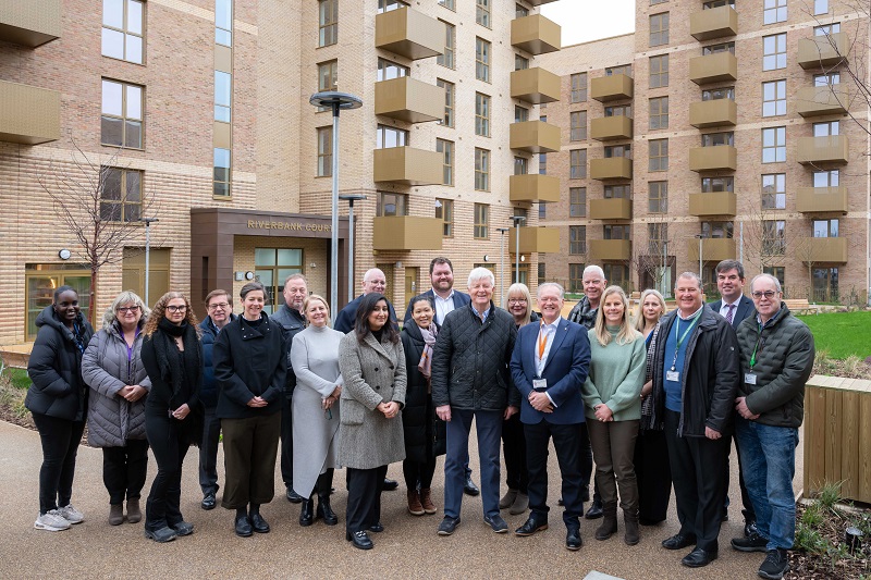 Image shows representatives from Wates and Havering Council in front of one of the new blocks at Park Rise, smiling at the camera