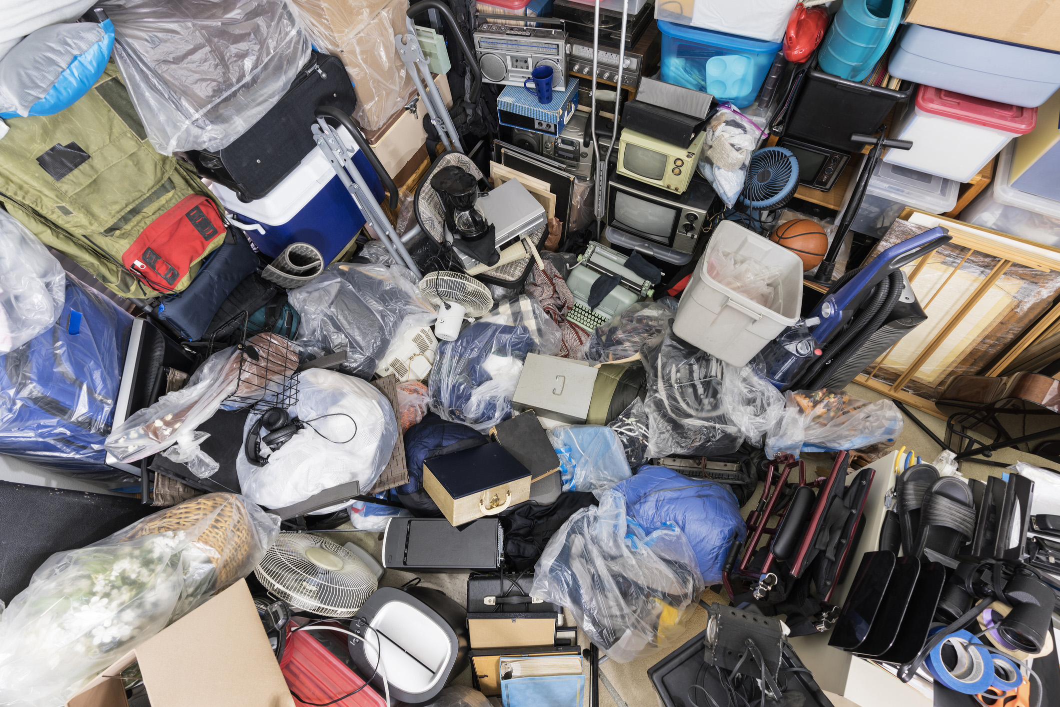 Image shows a room filled with pilled items across the whole space, representing a hoarding situation