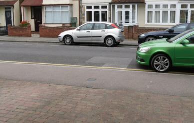 Car parked partially across a driveway where it could still be possible to access the driveway.