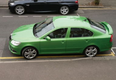 car parked across a dropped kerb with a  yellow line across it.